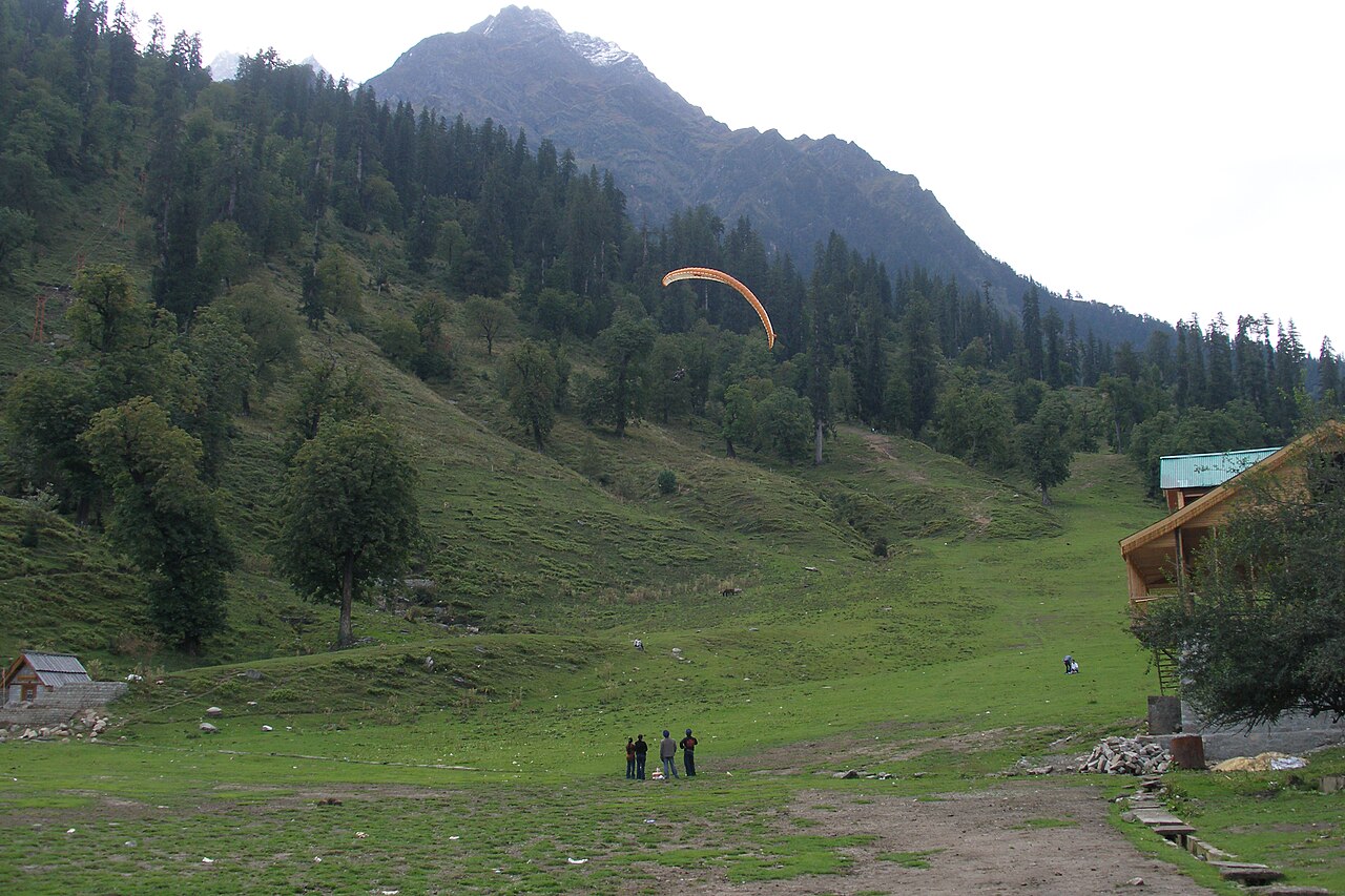 Green slopes and a paraglider in Solang Valley near Manali
